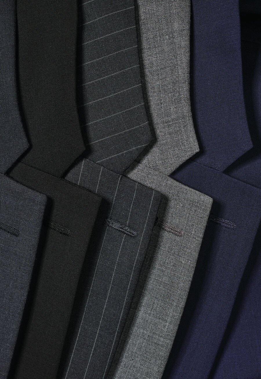 Row of suit fabrics in black, pinstripe, grey and navy
